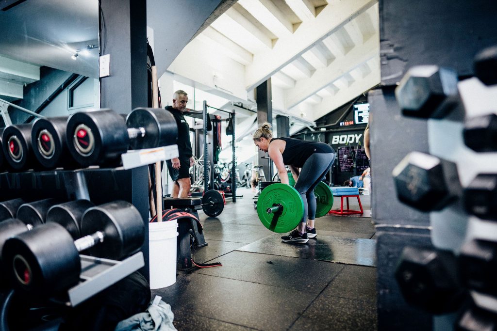 Alex Flint coaching a female client on deadlift technique at Body Torque Gym in Newmarket, Auckland.