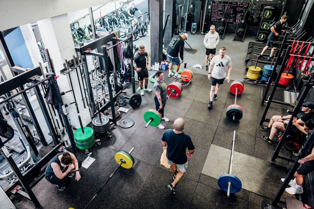 Group strength training session at Body Torque Gym in Newmarket with members lifting barbells under expert coaching.