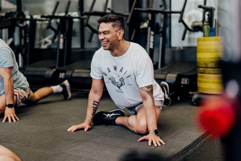Male member stretching and smiling after a training session at Body Torque Gym in Newmarket, Auckland.