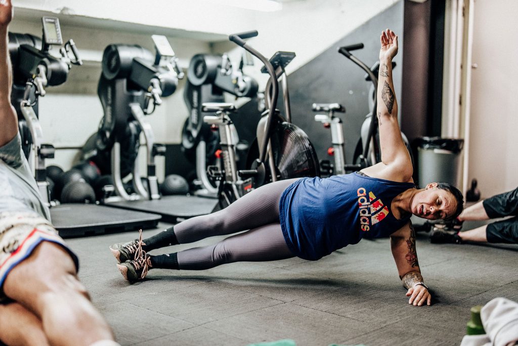 Female member performing a side plank exercise at Body Torque Gym in Newmarket, Auckland, to build core strength and stability.