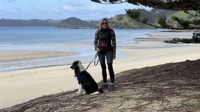 Body Torque Gym member Mary walking with her dog Cooper on the beach during active retirement.